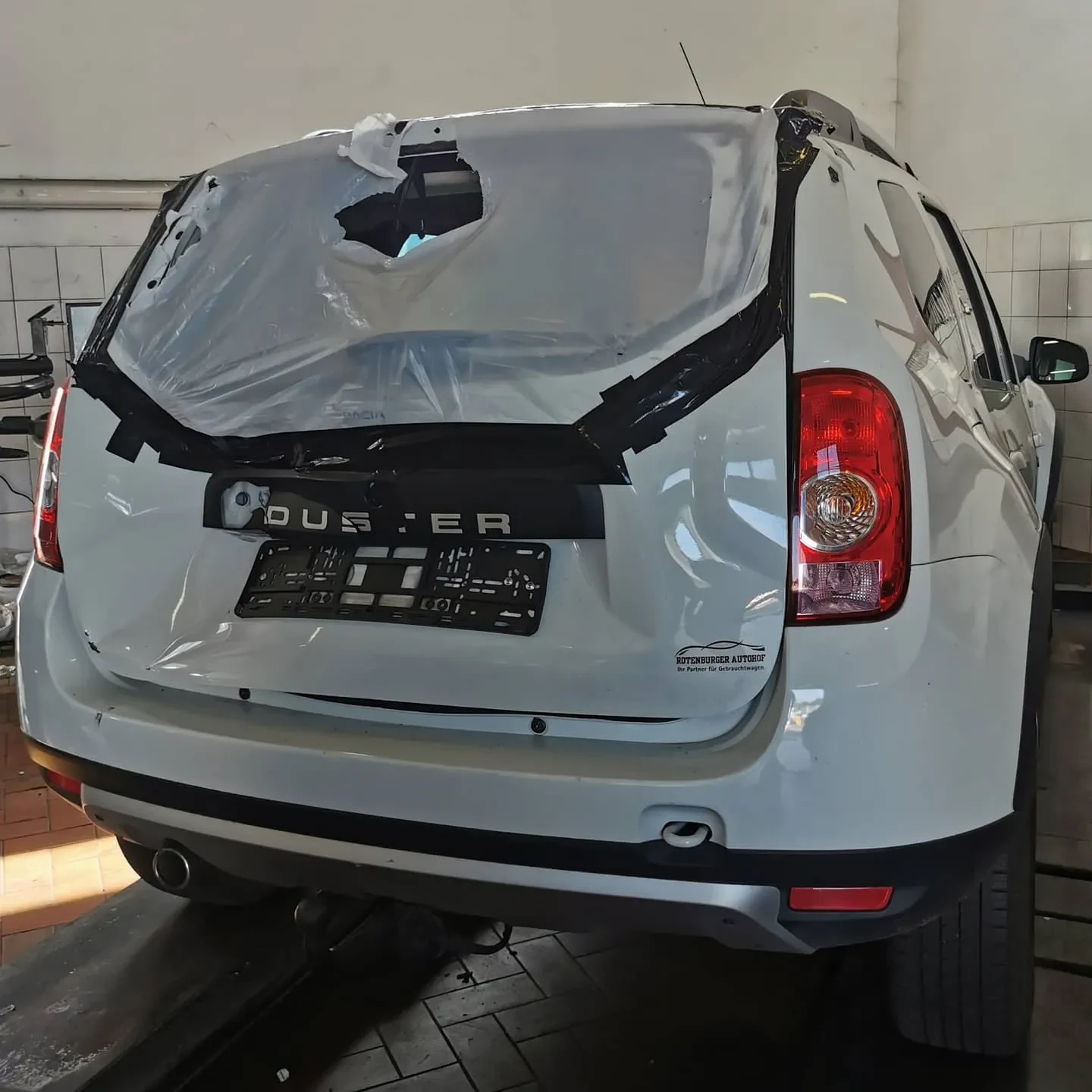 Dacia Duster mit beschädigtem Heck vor der Instandsetzung